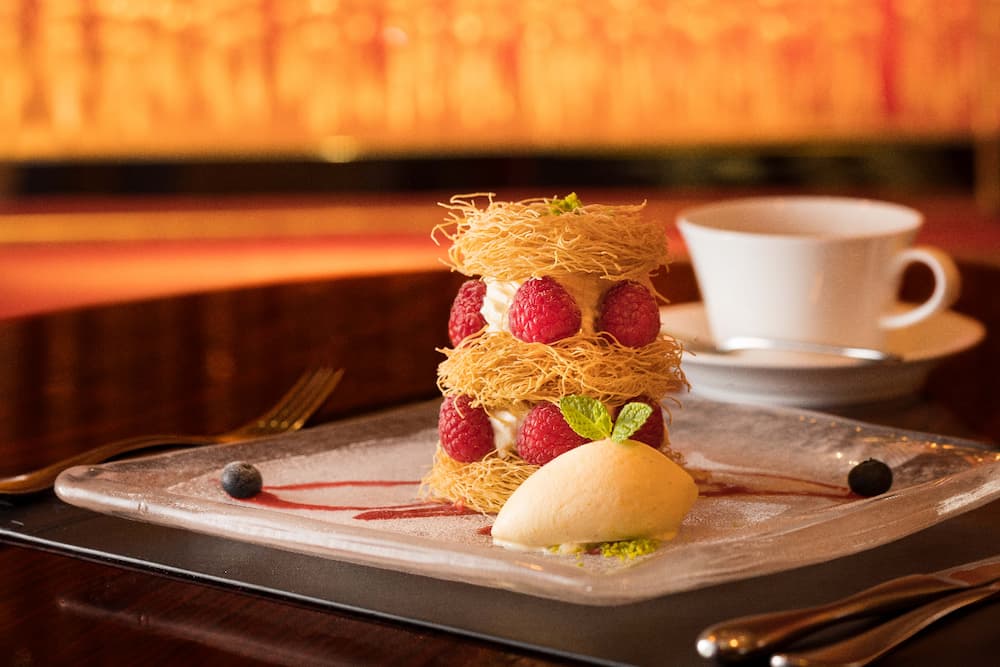 自開幕以來始終穩坐人氣冠軍的甜點「Joel-Robuchon千層酥～天使之髮～」。極細麵絲狀酥皮-Kadaif夾入馬斯卡彭起司與鮮奶油慕斯，入口直呼天堂。©Joel-Robuchon