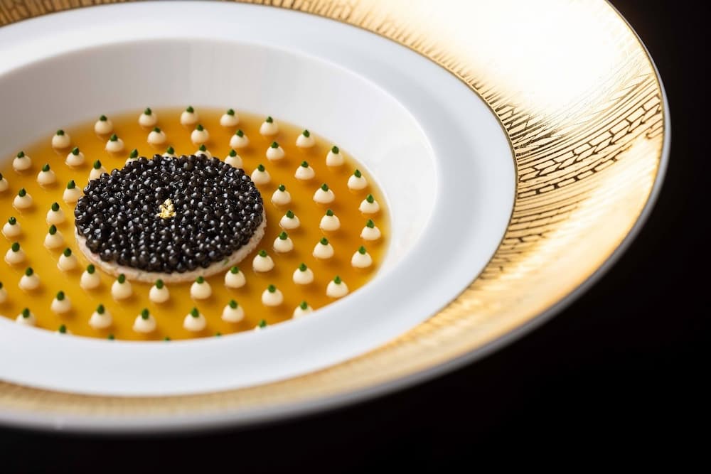 象徵-Joel-Robuchon-的招牌料理之一：「法國-索洛涅產魚子醬-Joel-Robuchon-風格」。底層鋪上甲殼類高湯凍，上層以花椰菜奶醬與蟹肉沙拉再佐以魚子醬，成就一道極致之作。©Joel-Robuchon