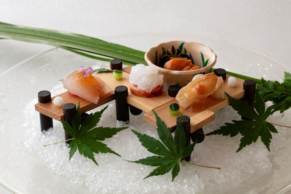 透明冰皿、襯托季節感的青葉，整齊細緻切片的魚料，散發清涼雅致的氛圍。©銀座-小十